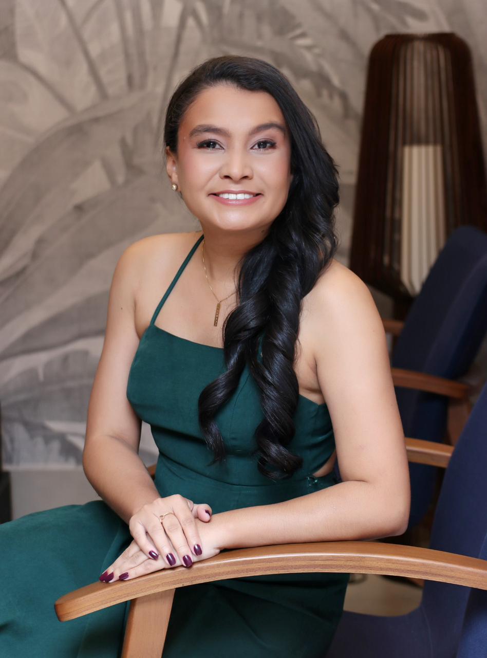 Natália Nogueira, GoHighLevel specialist, smiling in a green dress